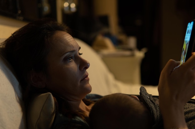 Close-up of woman using phone while lying at home