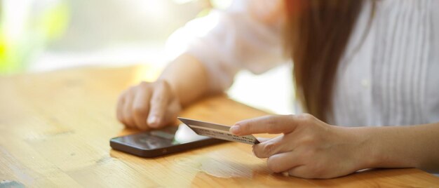 Close-up of woman using smart phone on table