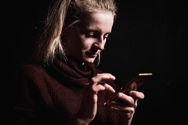 Photo close-up of woman using smartphone in darkroom