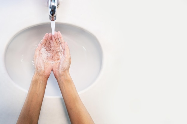 Foto prossimo piano di una donna che si lava le mani sotto l'acqua corrente per proteggersi