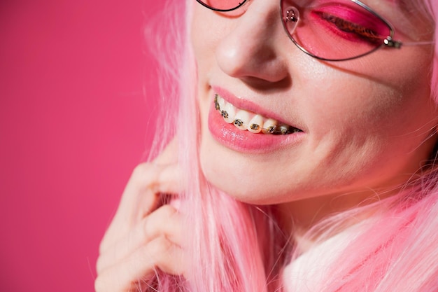 Photo close-up of woman wearing braces against colored background