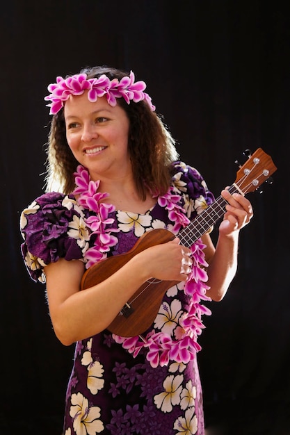 Foto close-up di una donna che indossa fiori con la chitarra in piedi contro il muro