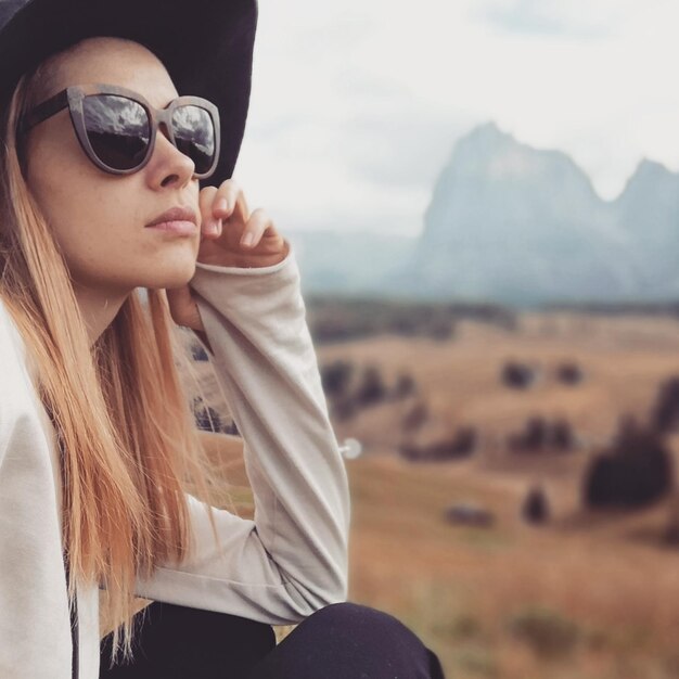 Photo close-up of woman wearing sunglasses against mountains