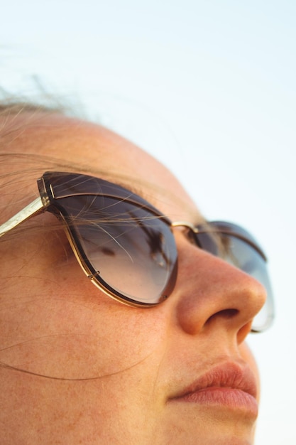 Close-up of woman wearing sunglasses against sky