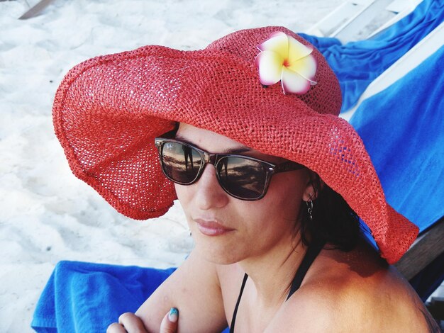 Photo close-up of woman wearing sunglasses and red hat at beach