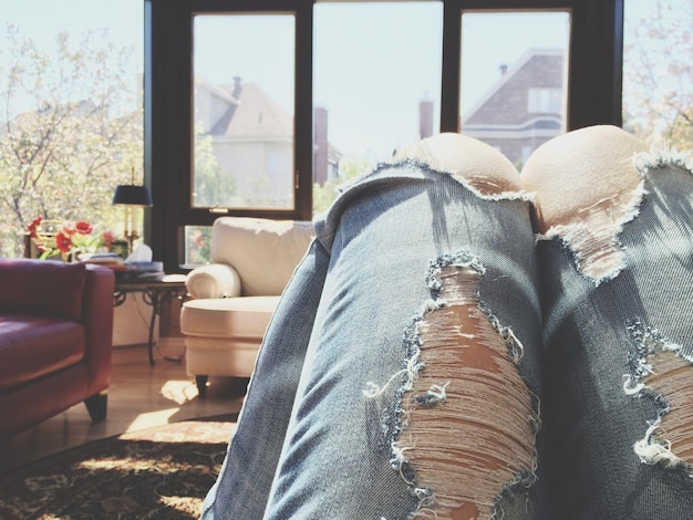 Foto close-up di una donna che indossa jeans strappati