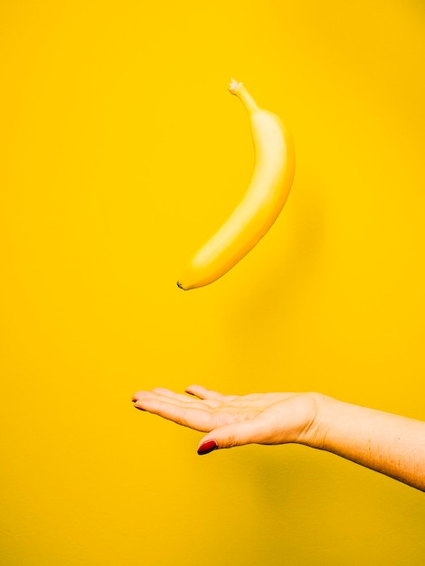 close-up of woman with banana against yellow background