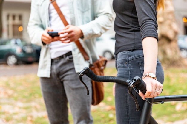 自転車を持つ女性と電話を持つ男のクローズアップ