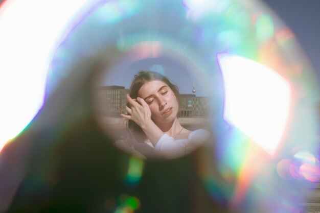 Photo close-up of woman with closed eyes standing against buildings