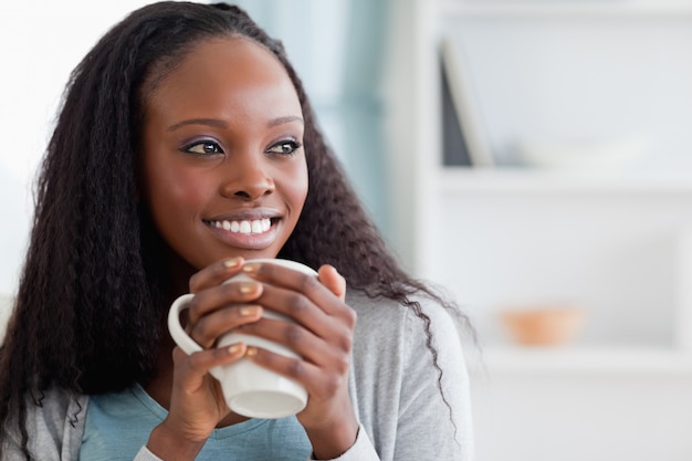 Close up of woman with a cup on couch