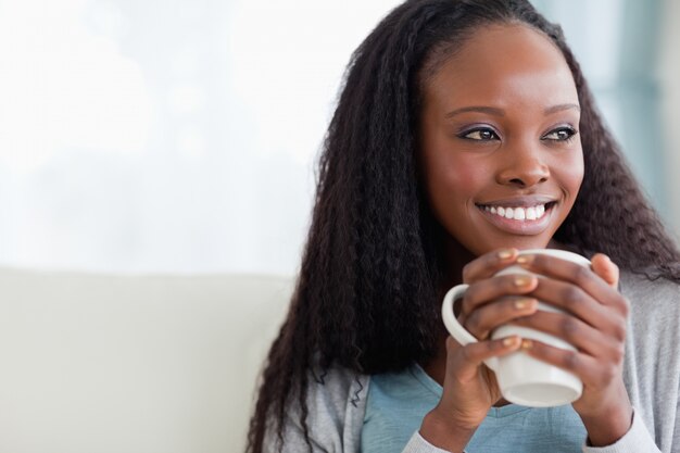 Close up of woman with a cup on sofa