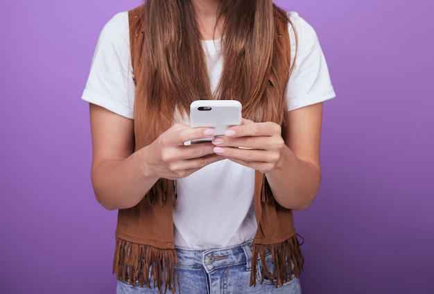 Close-up of a woman with dark hair holding a phone in her hands.