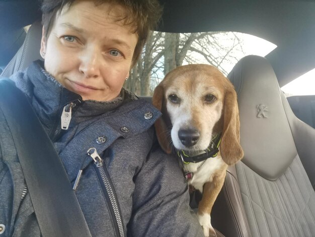 Close-up of woman with dog in car