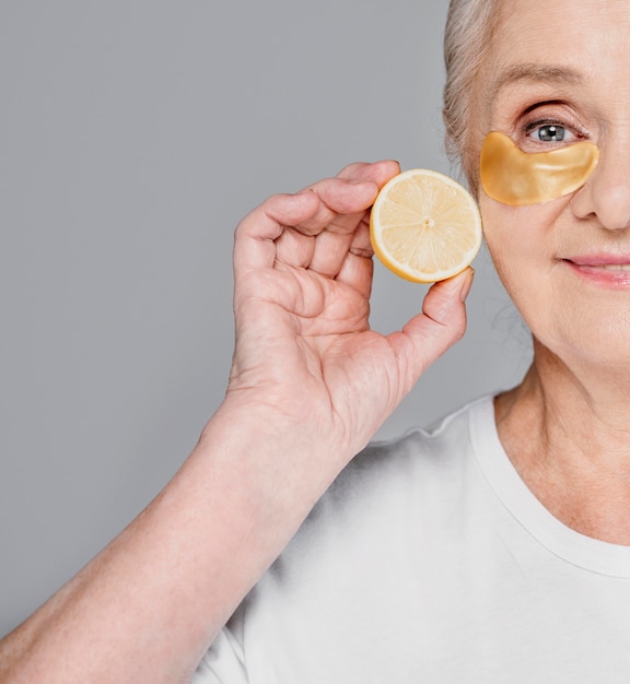 Close-up woman with eye patch and lemon