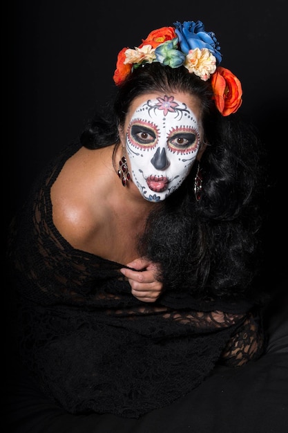 close-up of woman with face paint sitting over black background