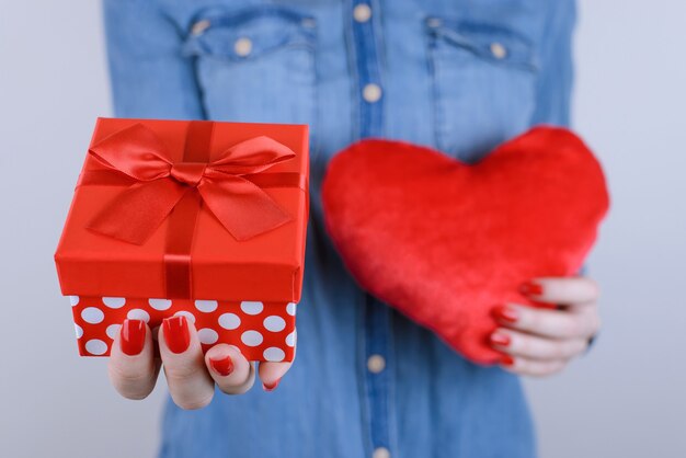 Foto primo piano di donna con giftbox e cuore nelle mani isolate