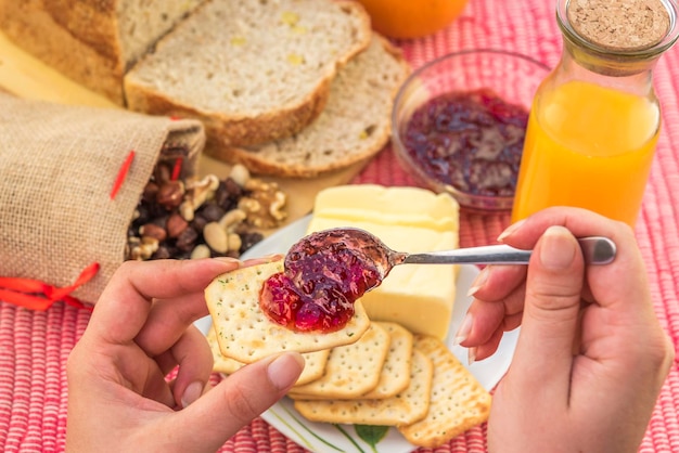 Close-up of woman with jam and crackers