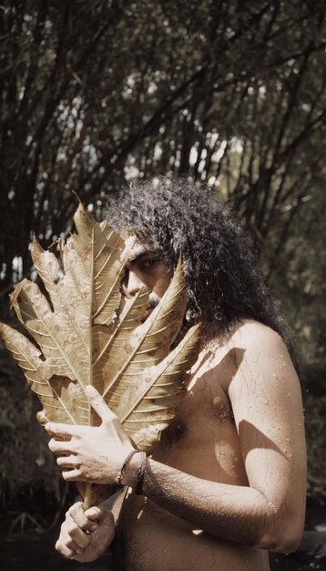 Foto close-up di una donna con le foglie su un albero nella foresta