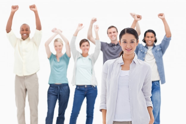 Close-up of a woman with people raising their arms 