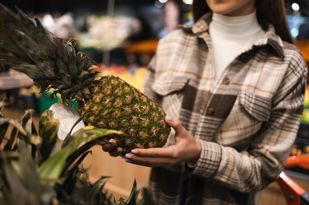 Close up of woman with pineapple in grocery market