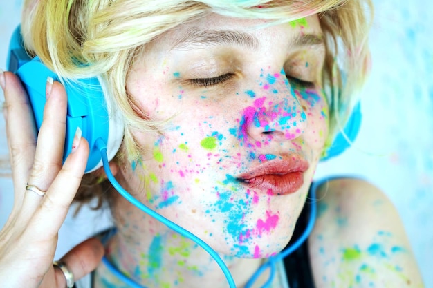 close-up of woman with powder paint on her face listening music