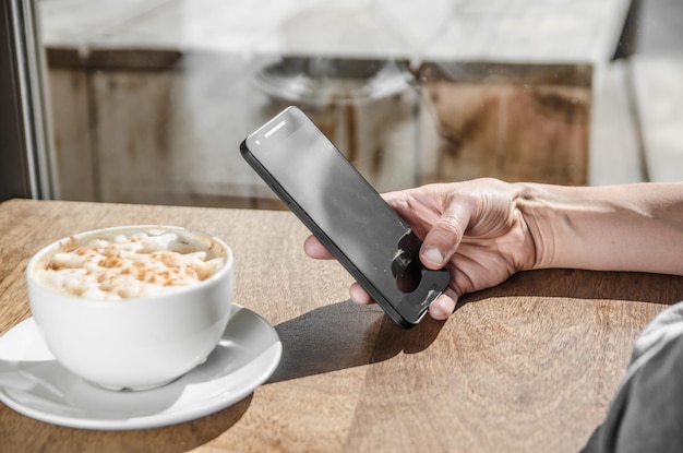 close-up of woman with smart phone and coffee