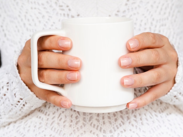 Close-up woman with sweater and white mug 