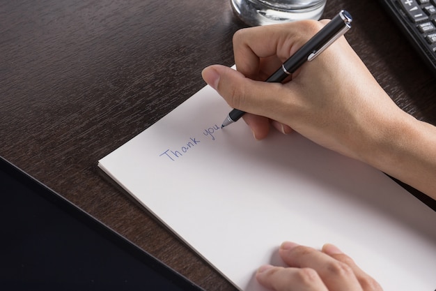 close up of woman with tablet and write a paper 