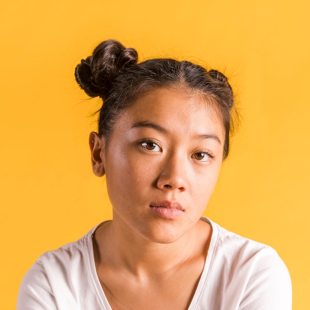 Close-up woman with tied hair looking at camera