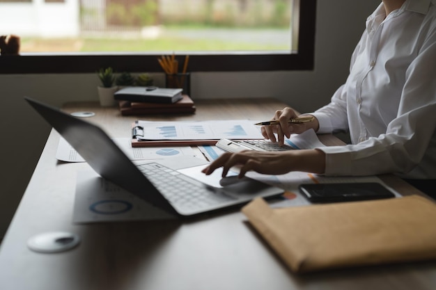 Close up a woman working about financial with calculator at his office to calculate expenses Accounting concept