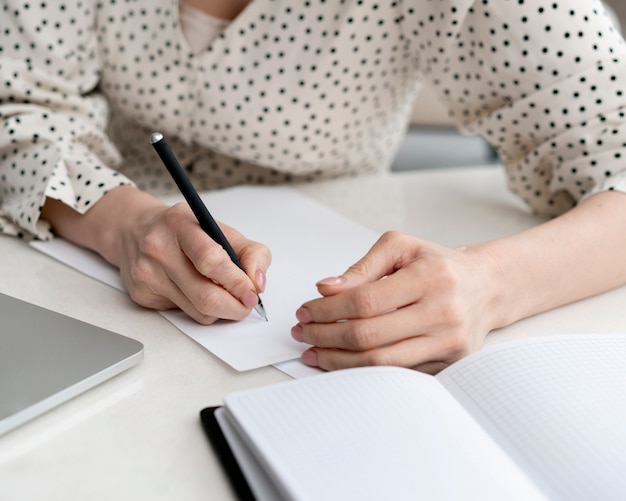 Close-up woman writing papers