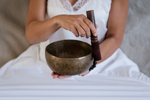 Foto chiuda su della mano di una donna mentre praticano l'yoga a casa