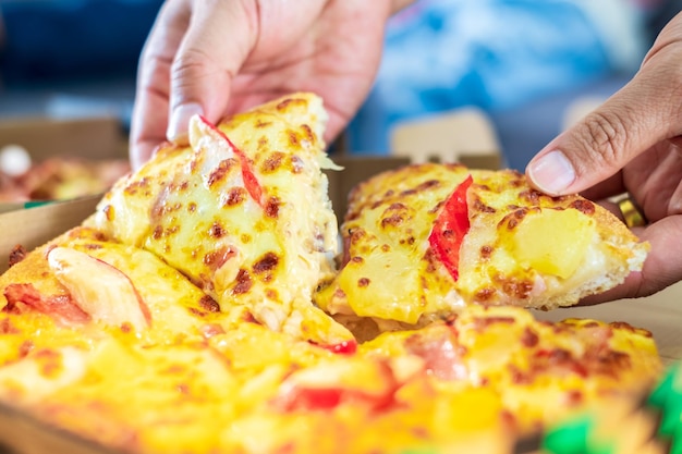 치즈 맛있는 신선한 피자를 어내는 여성의 손의 클로즈업 음식 배달 가정 개념