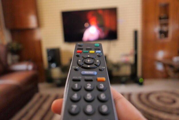 close up of women hand holding tv remote