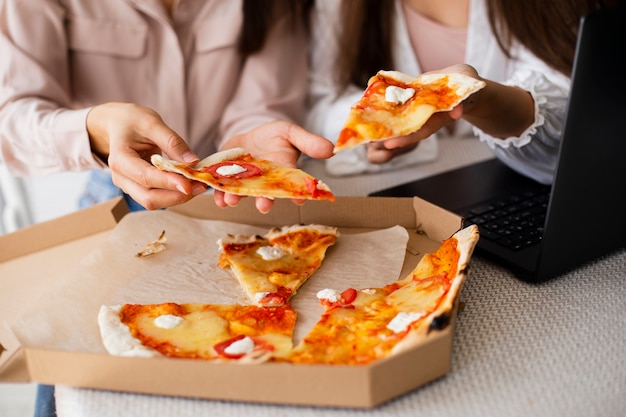 Foto pizza della scatola di pranzo delle donne del primo piano