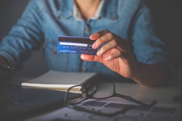 Close up of women's hand using laptop  for shopping online or payment with credit card.Shopping online concept.