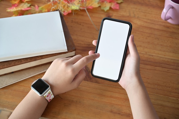 Close up of women's hands holding mobile phone with blank screen.