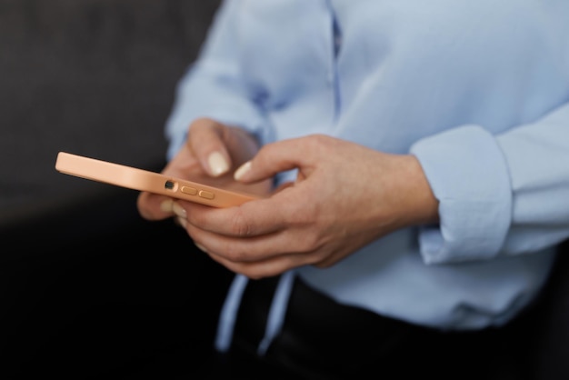 Foto primo piano delle mani delle donne che tengono il messaggio di testo del telefono cellulare o la ragazza dei pantaloni a vita bassa del contenuto promozionale