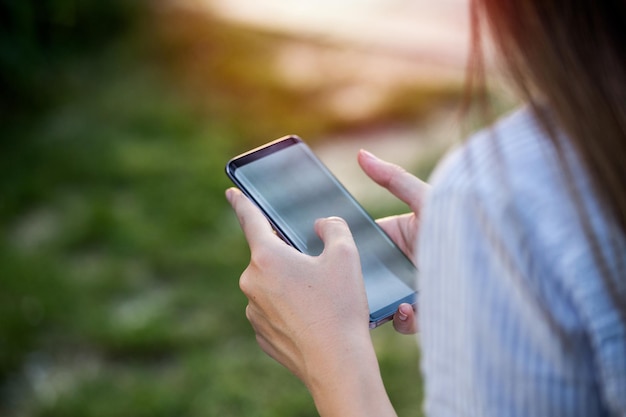 Close up of womens hands holding cell telephone with blank copy space scree for your advertising text message or promotional content