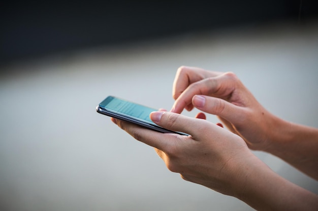 Close up of womens hands holding cell telephone with blank copy space scree for your advertising text message or promotional content