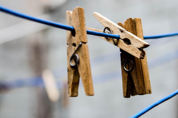 Foto close-up di pinze di legno attaccate al filo da bucato