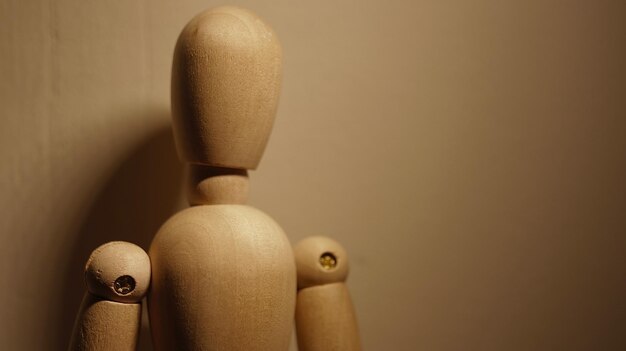 Close-up of wooden figurine against wall