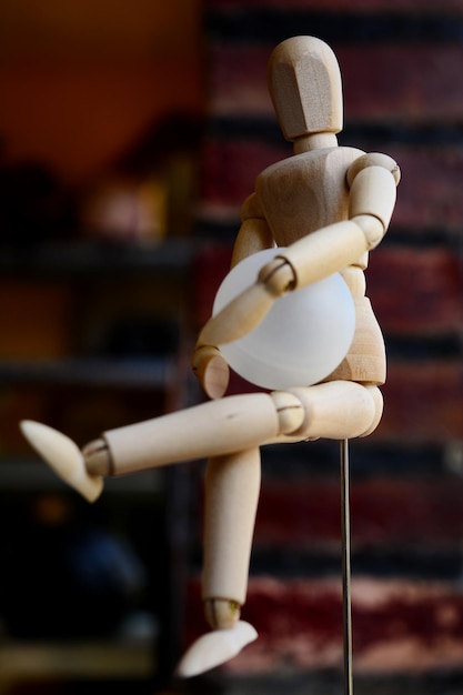 Close-up of wooden figurine holding ball