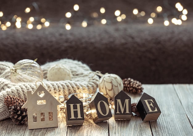 Close up of wooden letters make the word home, on blurred background with bokeh.