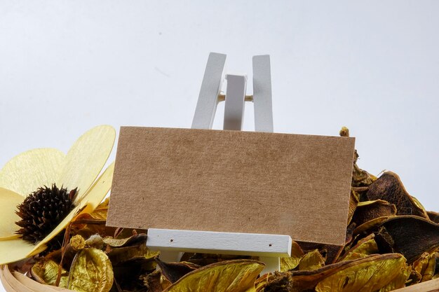 Photo close-up of wooden plank with autumn leaves and flower against gray background