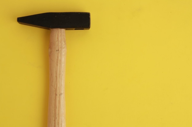 Foto close-up di un palo di legno contro un muro giallo