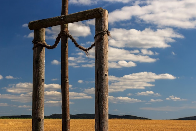 Foto close-up di un palo di legno sul campo contro il cielo