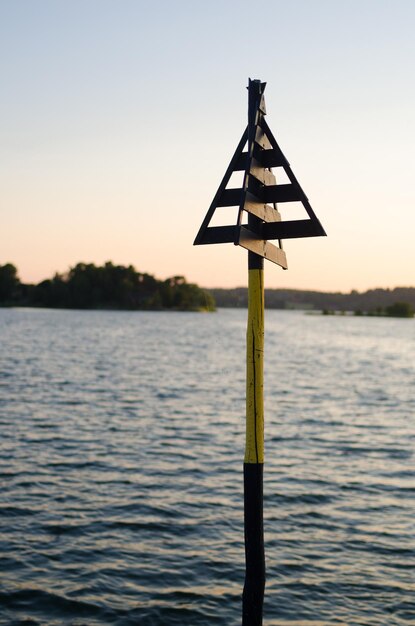 Foto close-up di un palo di legno nel lago contro il cielo