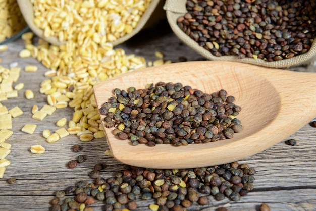 Close up of a wooden spoon full of lentils