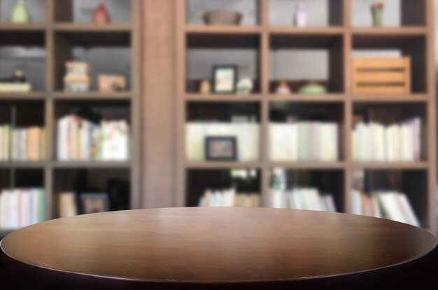 Photo close-up of wooden table against bookshelf in library